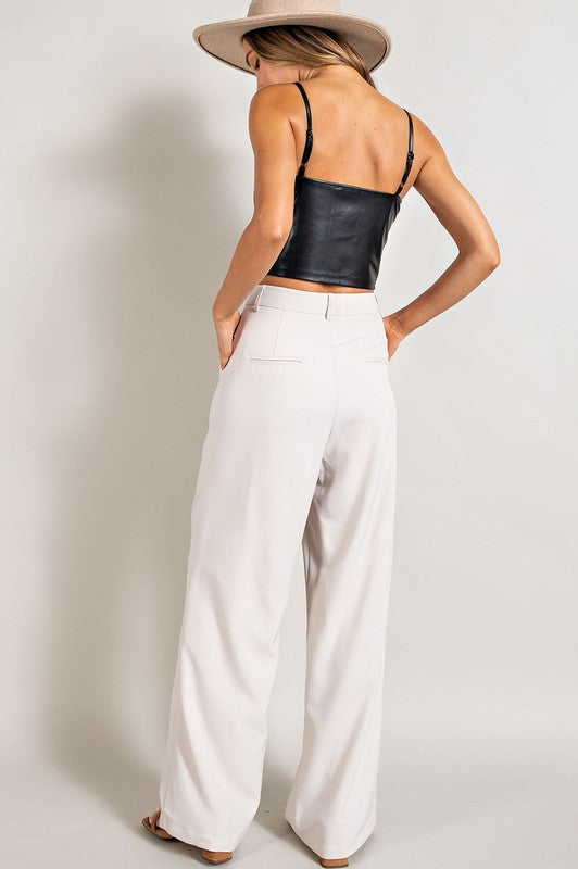 Flowy white straight leg pants with pleats, pockets, and relaxed fit.
