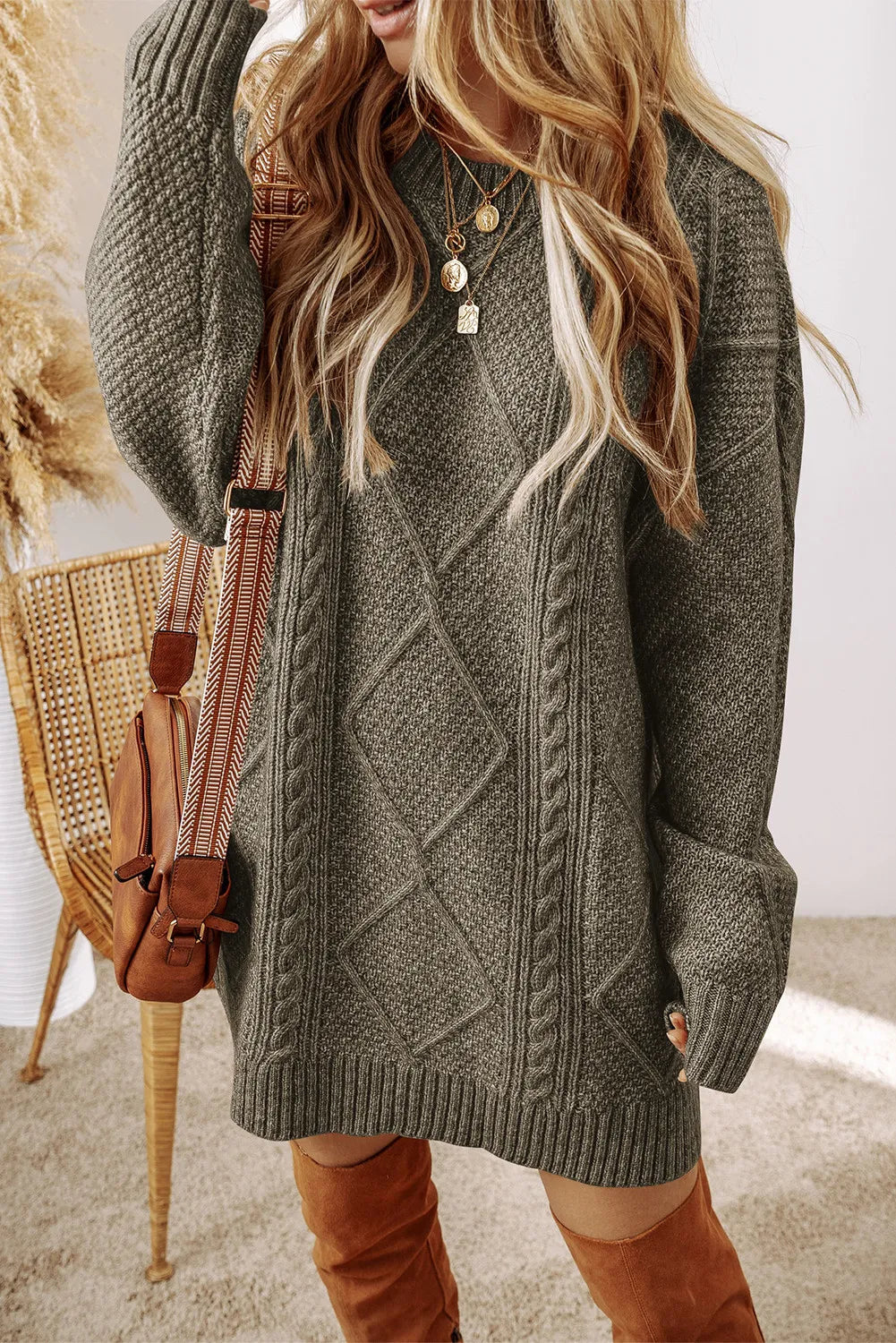 Woman wearing a cable-knit round neck sweater dress in soft polyester fabric