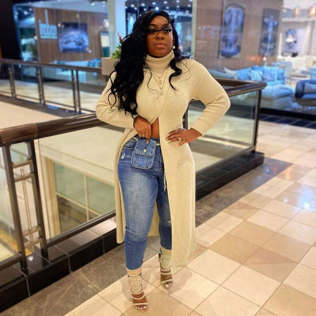 Pullover split sweater dress with high neck and long sleeves, styled casually with jeans, ideal for fall/winter.